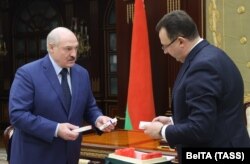 Health Minister Dzmitry Pinevich presents a batch of Russia's Sputnik V vaccine to Alyaksandr Lukashenka in Minsk on March 26, 2021.