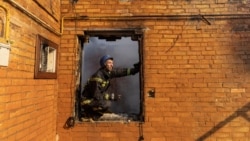 Украинский пожарный разбирает завалы в Киеве после военного удара 23 марта 2022 года