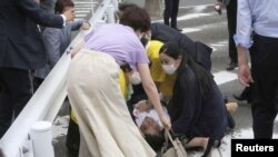 Свиедетели пытаются оказать помощь умирающему Синдзо Абэ. Город Нара, 8 июля 2022 года