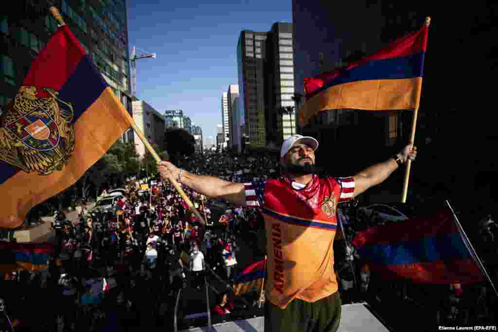Arkady Grigorian stands on the roof of an RV waving Armenian flags as thousands of American-Armenian protesters march in front of Turkey&#39;s consulate in Los Angeles, California on October 11.&nbsp; Southern California is estimated to contain the world&#39;s largest Armenian diaspora.&nbsp;