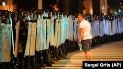A protester speaks to police blocking a road in Minsk during a protest that followed the Belarusian presidential election on August 9, 2020.