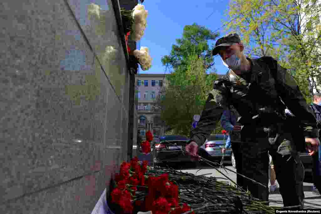 A serviceman lays flowers at a makeshift memorial outside the Republic of Tatarstan&#39;s office in Moscow to commemorate victims of the May 11, 2021 shooting at Kazan&#39;s School No. 175.