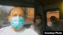 Journalists Sergei Smirnov, Tatyana Felgenhauer, and Aleksandr Plyushchev shown in a police van on May 28, 2020