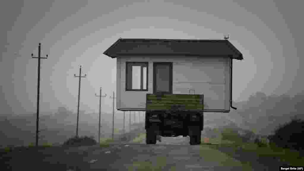 NAGORNO-KARABAKH -- A family drives a truck loaded with a small house along a highway as they leave their home village in the separatist region of Nagorno-Karabakh, November18, 2020