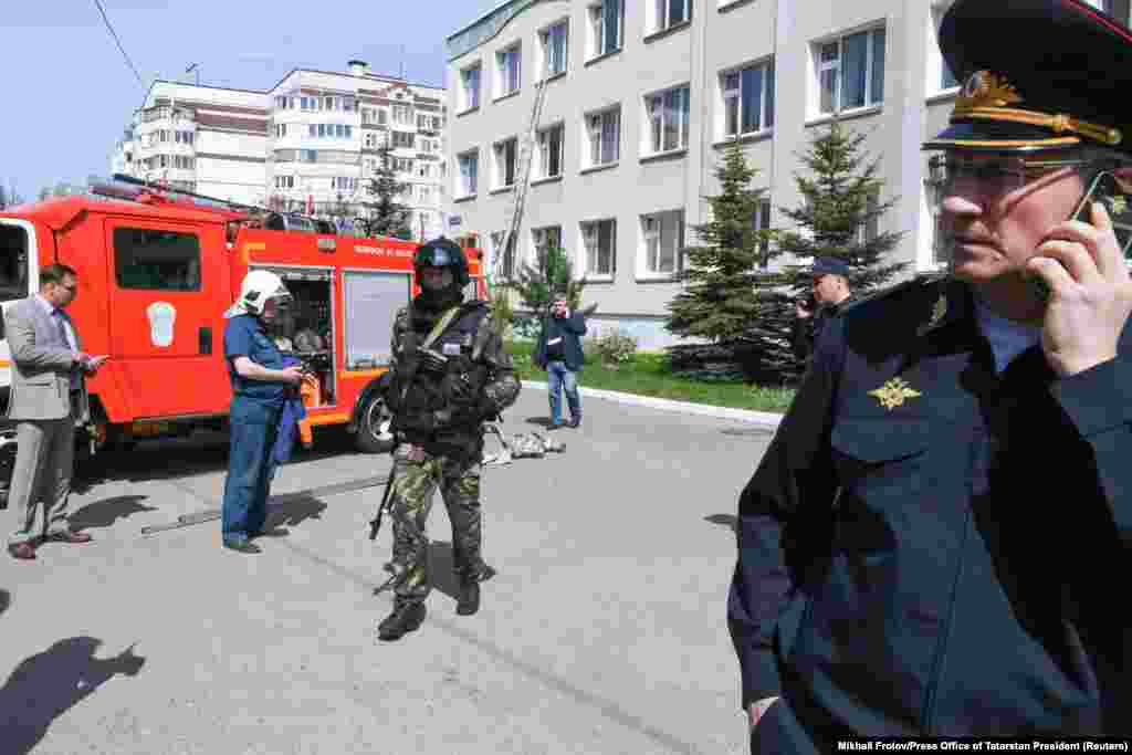 Law enforcement and employees of the Emergencies Ministry stand outside of Kazan&#39;s School No. 175. To assist victims, the government has pledged to pay each affected family 1 million rubles (about $13,500) and to allocate to each of the wounded the ruble-equivalent of $2,700 to $5,400, AP reported.&nbsp; &nbsp;