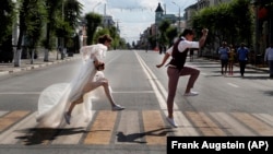  Newlyweds pose for wedding photographers on a zebra crossing during the July 2018 soccer World Cup in Samara, Russia.