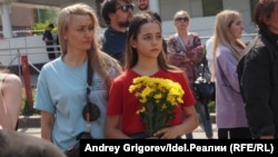 Parents and children in Kazan wait to leave flowers and stuffed animals at a memorial to the victims of the May 11, 2021 attack on School No. 175. 