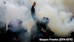 Ukrainian activists throw smoke flares during an October 30, 2020 rally outside Kyiv's Constitutional Court building. The demonstrators demanded that the judges come out and explain their reasons for ruling against criminal penalties for false financial disclosures by officials. 