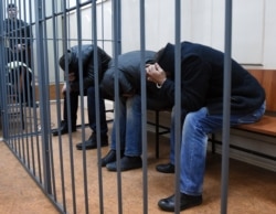 Three unidentified Nemtsov murder suspects in the defendants’ cage in Moscow’s Basmanny District Court on March 8, 2015