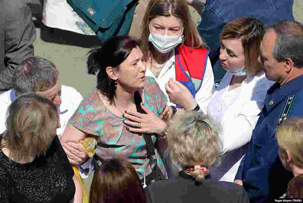 Nurses comfort relatives of students at Kazan&#39;s school No. 175. At least seven children were among the nine people killed there on May 11, 2021. Eighteen of the 21 people reported wounded are children.