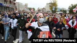 A young Belarusian protester, carrying a fake sword emblazoned with the word "Solidarity," marches with others in Minsk on September 27 to reject Belarus' official presidential election results and Alyaksandr Lukashenka's inauguration as president.