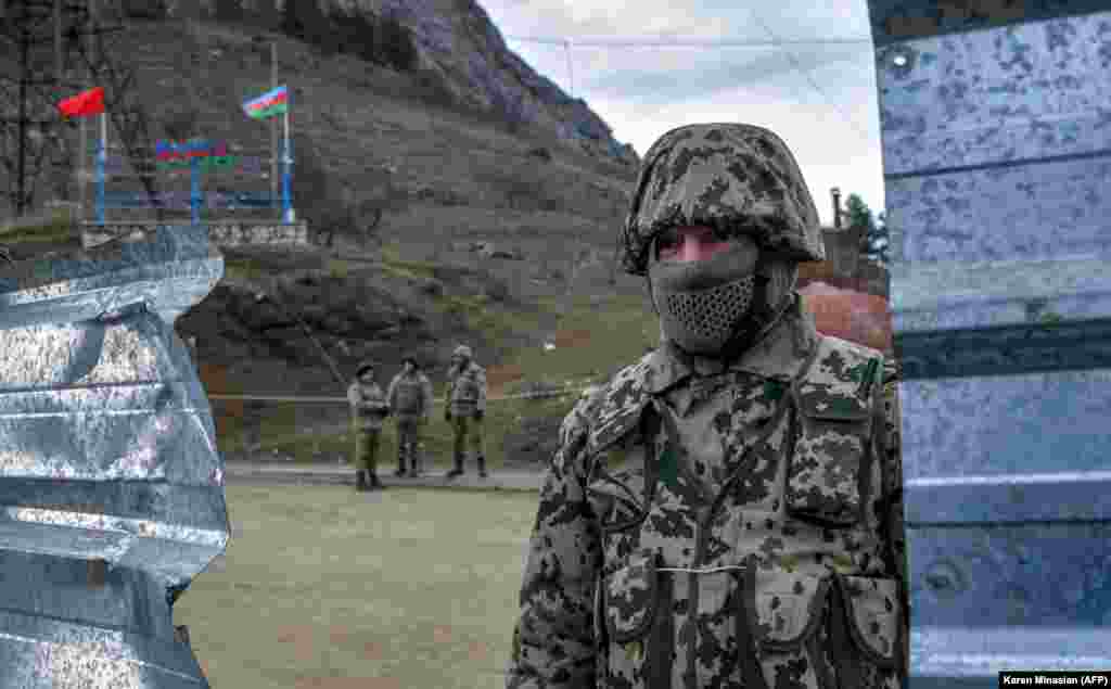 Azerbaijani soldiers stand at a checkpoint on a road outside the Nagorno-Karabakh town of Shusha (Shushi in Armenian) on November 26, 2020. After Azerbaijan regained control of the town in early November, relatively little has been reported about conditions there. Shusha, located about 10 kilometers from Karabakh&#39;s seat, Khankendi (Stepanakert), was seen as a strategic win for Azerbaijan because of its hilltop position.&nbsp;
