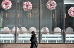 A woman walks past a closed cafe in the center of the Ukrainian capital, Kyiv, on March 16, 2020.