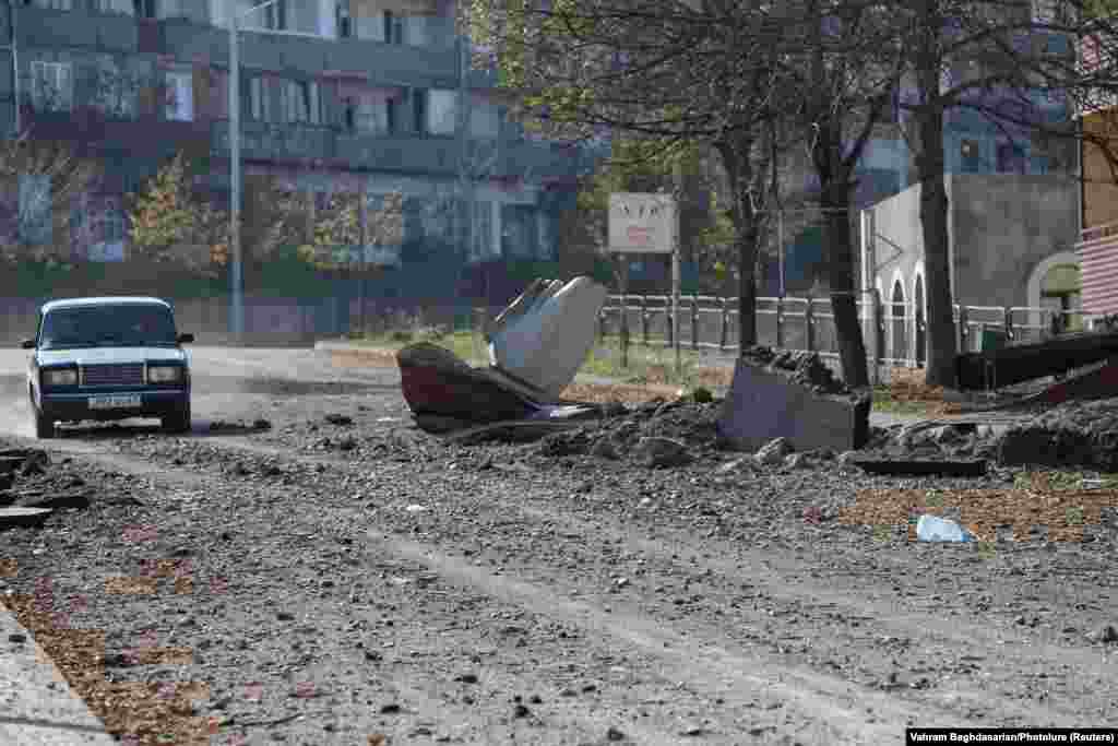 NAGORNO-KARABAKH -- People drive a car near a damaged building following recent shelling in the town of Shushi (Susa), in the course of a military conflict over the breakaway region of Nagorno-Karabakh, October 29, 2020