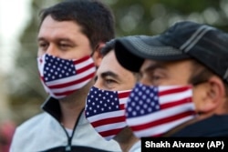 Supporters of the United National Movement, a strongly pro-U.S. party, wear face masks with the Georgian and U.S. flags at a campaign rally in Tbilisi on October 29, 2020.