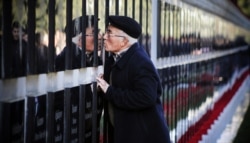 On the 29th anniversary of Black January, a man kisses a tomb stone at the Alley of Martyrs, a cemetery and memorial dedicated to those killed by Soviet troops on January 20, 1990 in Baku.