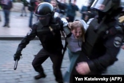 Policemen detain protester Daria Sosnovskaya after an August 10, 2019 rally urging fair elections in Moscow. Video showed a uniformed officer punching Sosnovskaya in the stomach.