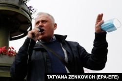 Opposition leader Mikalay Statkevich holds a face mask while talking to his supporters during a May 24, 2020 rally in Minsk, Belarus for that year's presidential elections.