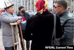 Samat Okmutkolov (left) talks with fellow veterans of the 2020 election protests in downtown Bishkek on the October 5, 2021 anniversary of the uprising.