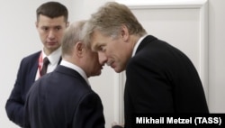 Russia's President Vladimir Putin talks to spokesman Dmitry Peskov during a 2019 meeting with Turkish President Recep Tayyip Erdogan.