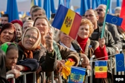 People wave flags at a 2013 demonstration in the Moldovan capital, Chisinau, to support Moldova receiving an Association Agreement with the European Union.