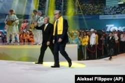 Interim Kazakh President Qasym-Zhomart Toqaev (right) and former Kazakh President Nursultan Nazarbaev greet their supporters in Nur-Sultan on June 7, 2019.