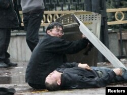 A victim of clashes between Kyrgyz riot police and anti-government protesters lies on the ground near the presidential administration building in Bishkek on April 7, 2010.