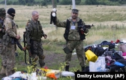 A pro-Russia fighter holds up a toy found among the debris at Malaysia Airlines Flight MH17's crash site in Ukraine's Donetsk region.