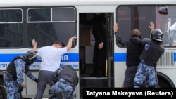 Law-enforcement officers detain a participant in the rally.