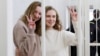 Belsat TV journalists Katsyaryna Andreyeva (r) and Daria Chultsova (l), who were detained in November 2020 while reporting on anti-government protests, flash the V-sign from a defendant's cage during their trial in Minsk on February 18, 2021.