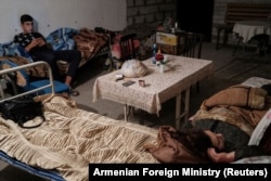 People are seen in a basement used as a shelter from artillery fire in Stepanakert, the capital of the breakaway Nagorno-Karabakh region, on September 28, 2020.