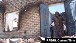 Mubora Abdukhamitova, a resident of the Kyrgyz village of Makrat, surveys the ruins of her son's house after the April 28-April 29 border conflict between Kyrgyz and Tajiks over a water canal and pumping station. 