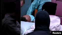 A video grab shows medical specialists carrying Russian opposition leader Aleksei Navalny on a stretcher into an ambulance on their way to the airport before his medical evacuation from the Russian city of Omsk to Germany on August 22, 2020