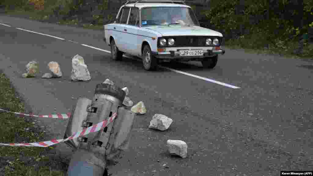 A rocket fragment on a road near the Karabakhi town of Shusha (Shushi in Armenian), just over a week before Azerbaijani forces retook control of the town from ethnic Armenian separatists on November 8, 2020. A subsequent truce between Armenia, Azerbaijan, and Russia formally turned Shusha over to Azerbaijan and will introduce nearly 2,000 Russian peacekeepers into Nagorno- Karabakh. Three days after the agreement went into effect on November 10, 2020, a Russian peacekeeper and Azerbaijani service member stood together on a road in Shusha&#39;s outskirts.&nbsp;