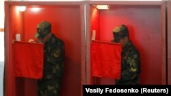 Belarusian servicemen take part in early voting at a polling station in Minsk, five days ahead of Belarus' August 9 presidential election. 