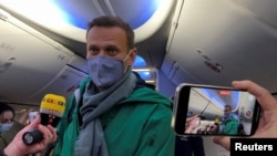 Russian opposition leader Aleksei Navalny boards a January 17, 2021 flight from Berlin to Moscow after completing medical treatment in Germany for a Novichok nerve-agent poisoning. 