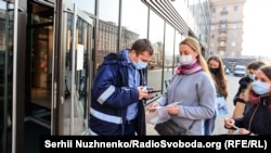 An employee checks the documents of customers at the entrance to a cafe in Kyiv on November 1.