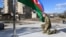 Azerbaijani President Ilham Aliyev kneels in front of the Azerbaijani flag during his visit to the Nagorno-Karabakh town of Shusha on January 15, 2021.