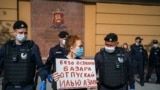 Police officers in Moscow detain Russian photographer Viktoria Ivleva during her May 28 solo protest outside of police headquarters in support of jailed journalist and activist Ilya Azar.   "Release Ilya Azar without any fuss," her sign reads. 