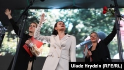Belarusian presidential candidate Svyatlana Tsikhanouskaya, flanked by allies Veranika Tsapkala (left) and Maryya Kalesnikava, addresses her July 30 rally in Minsk.