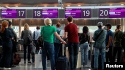 Passengers wait to check in for the last Belavia flight from Kyiv's Boryspil International Airport to Minsk on May 25, 2021.  
