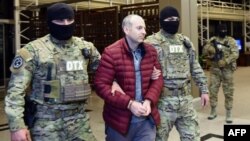 Travel blogger Aleksandr Lapshin is met by Azerbaijani security offers upon his landing in Baku after being extradited from Belarus in 2017. 