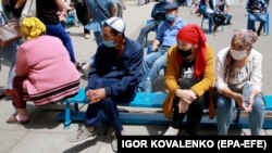 Bishkek residents wait for their turn to receive medical care near a day hospital in the Kyrgyz capital on July 6, 2020.