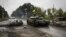 Украинский танк проезжает мимо бывшего российского блокпоста под Изюмом в Харьковской области